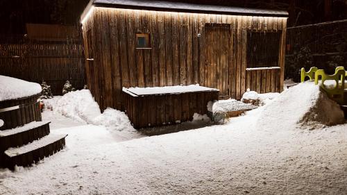 a yard covered in snow next to a wooden building at Apartments Daina in Jūrmala