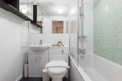 倫敦的住宿－The Camberwell Apartment，浴室配有卫生间、盥洗盆和浴缸。