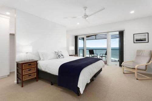 a bedroom with a bed and a table and a chair at Rip n View in Point Lonsdale