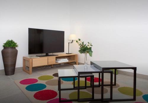 un salon avec une télévision et une table dans l'établissement La Croisette, à Cannes