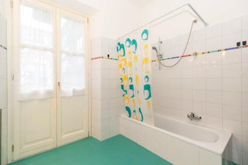 a white bathroom with a tub and a shower at Mercato Centrale Roomy Apartment in Turin
