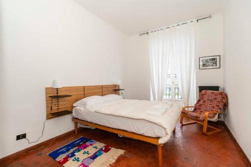 a bedroom with a bed and a chair at Mercato Centrale Roomy Apartment in Turin