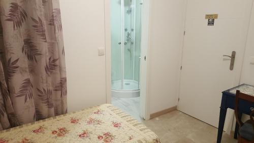 a bathroom with a shower and a bed in a room at hospedaje barahona21 in León