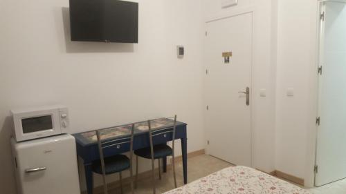 a room with a table with chairs and a microwave at hospedaje barahona21 in León