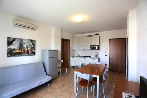 a living room with a couch and a table and a kitchen at Pini Village Lido Altanea in Caorle