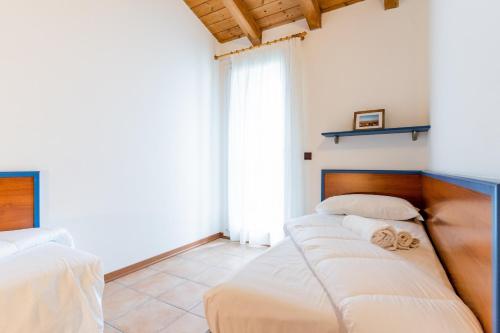um quarto com 2 camas e lençóis brancos em Pini Village Lido Altanea em Caorle