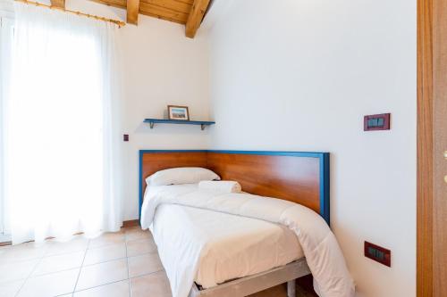 a bedroom with a bed with a wooden headboard at Pini Village Lido Altanea in Caorle