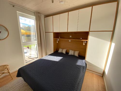 a small bedroom with a bed and a window at Tiny House mit Sauna am See in Repente