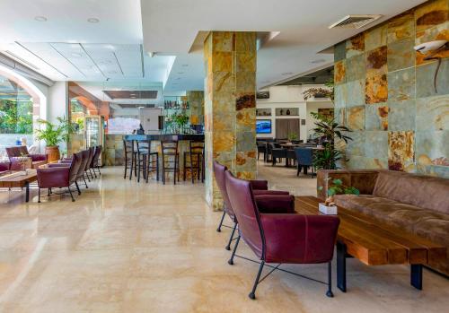 een lobby met een bank en tafels en stoelen bij Comfort Hotel Eilat in Eilat