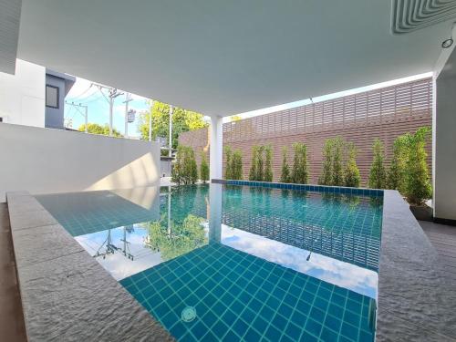 uma piscina no meio de uma casa em Be Phrasingh Hotel Chiang Mai em Chiang Mai