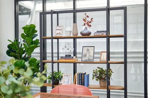 a black book shelf with books and vases on it at Be Phrasingh Hotel Chiang Mai in Chiang Mai