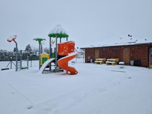 a playground in a park covered in snow at Apartamenty przy Jeziorze Żywieckim z widokiem na Skrzyczne in Żywiec