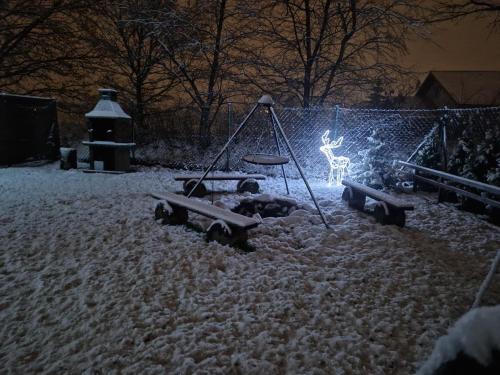 a playground in a yard covered in snow at Apartamenty przy Jeziorze Żywieckim z widokiem na Skrzyczne in Żywiec