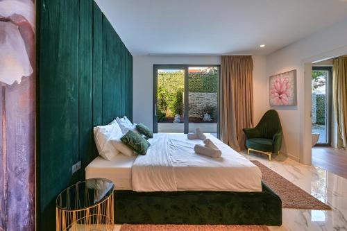 a bedroom with a large bed with a green wall at Villa Naya with Heated Pool and Hot Tub in Veprinac