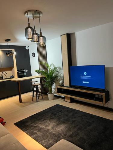 a living room with a large tv and a kitchen at Appartement Neuf- Morangis-Orly in Morangis