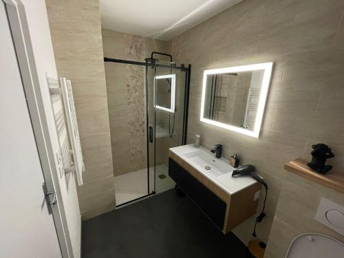 a bathroom with a sink and a glass shower at Appartement Neuf- Morangis-Orly in Morangis