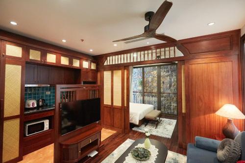 uma sala de estar com paredes de madeira e uma ventoinha de tecto em Camellia Residence Hanoi em Hanói