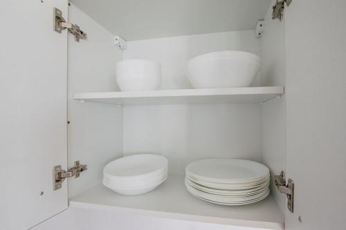 a kitchen with white plates and bowls on shelves at T&K Apartments - Duisburg - 4 Rooms Apartment - 2nd Floor in Duisburg