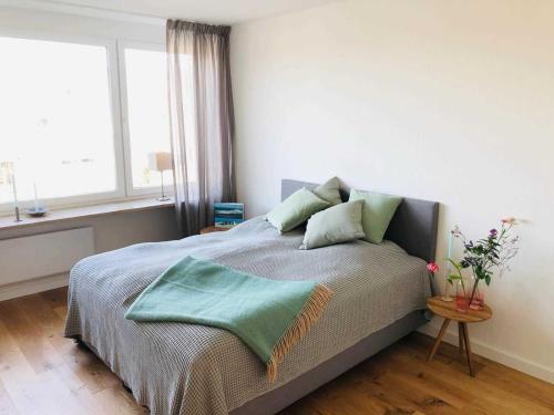 ein Schlafzimmer mit einem Bett mit einer grünen Decke darauf in der Unterkunft Haus Deckerstraße-Goebel in Westerland