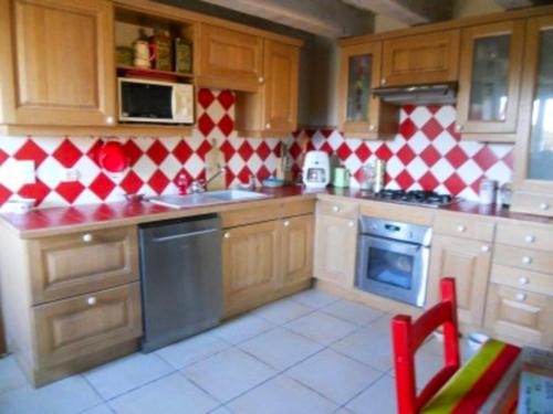 una cocina con paredes a cuadros rojas y blancas en Villa de 4 chambres avec piscine privee et jardin amenage a Saint Vincent Rive d'Olt, en Saint-Vincent-Rive-dʼOlt