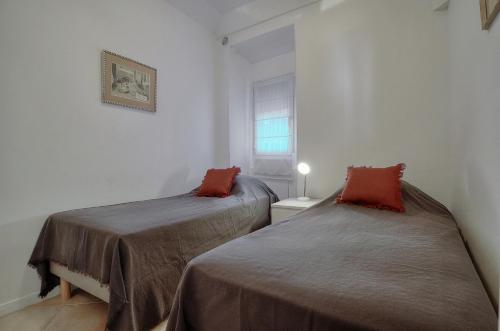 deux lits dans une petite pièce avec une fenêtre dans l'établissement 2 Pieces centre ville proche Palais A1B245, à Cannes