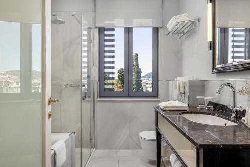 a bathroom with a toilet and a sink and a shower at Hotel Park Split in Split