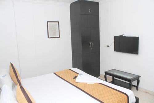 a room with a bed and a tv in it at Skyry Residency in Chennai