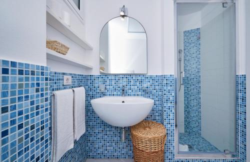 een blauwe betegelde badkamer met een wastafel en een douche bij Case Vacanze Pomelia in Marina di Ragusa