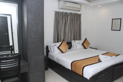 a hotel room with two beds and a window at Skyry Residency in Chennai