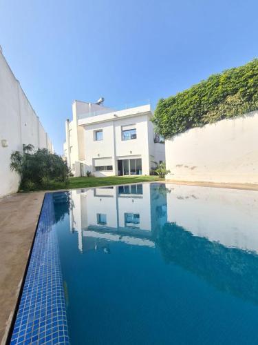 - une piscine en face d'un bâtiment blanc dans l'établissement Villa “el Jefe Del Mar”, à Casablanca