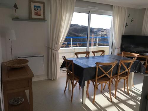 une salle à manger avec une table et des chaises et une fenêtre dans l'établissement Fort-Mahon-Plage: Appartement 3 chambres proche plage, grand balcon, parking - FR-1-482-42, à Fort-Mahon-Plage