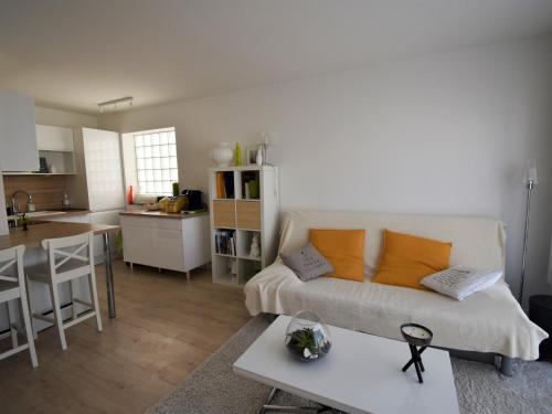 un salon et une cuisine avec un canapé et une table dans l'établissement Arcachon : T2 moderne à 2 pas de la plage avec balcon, WiFi, parking et TV cinéma - FR-1-420-71, à Arcachon