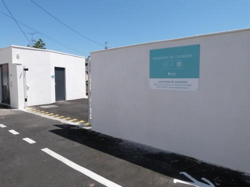a parking lot with a sign on the side of a building at Appartement plage, piscine, balcon, animaux, parking - FR-1-194-201 in La Tranche-sur-Mer