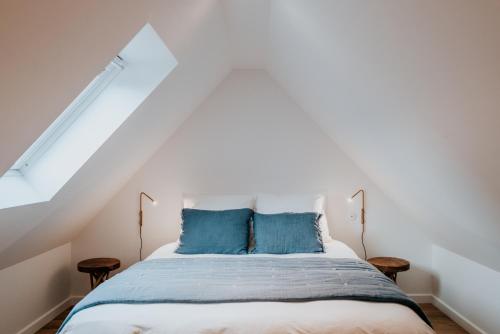 a bedroom with a bed with blue pillows at La Brise in Roscoff
