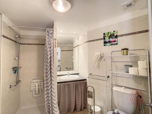 une salle de bain avec une douche, un lavabo et des toilettes dans l'établissement Appartement F2 Climatisé avec Terrasse et Parking à 700m des Thermes de Lamalou Les Bains - FR-1-451-121, à Lamalou-les-Bains