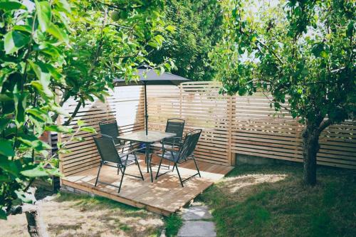 a table and chairs with an umbrella in a garden at The Palm House Falmouth - minutes from the beach! in Falmouth