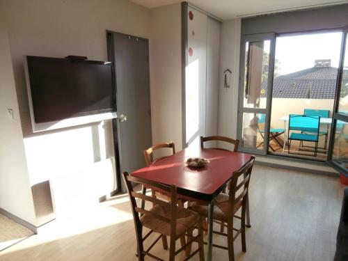 une salle à manger avec une table, des chaises et une télévision dans l'établissement Appartement Rénové avec Balcon, Proche Plage et Marché – 4 Pers, Calme & Confort à Seignosse - FR-1-239-460, à Seignosse