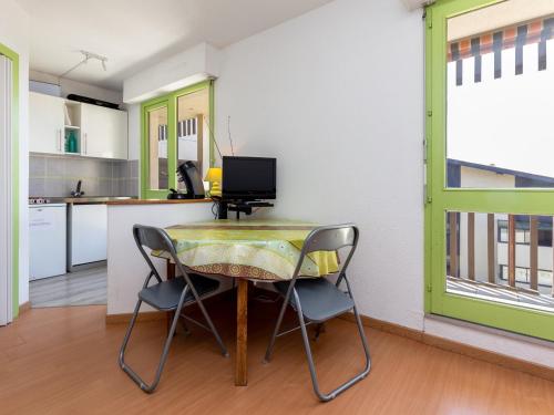 une petite cuisine avec une table et deux chaises dans l'établissement Appartement à Seignosse Plage - Terrasse Sud, Parking, Proche Océan et Parc Aquatique - FR-1-239-469, à Seignosse