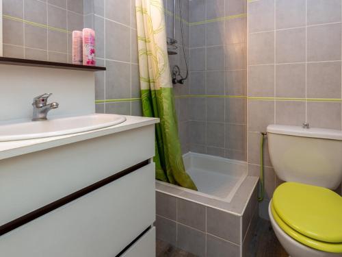 La salle de bains est pourvue de toilettes vertes et d'un lavabo. dans l'établissement Appartement à Seignosse Plage - Terrasse Sud, Parking, Proche Océan et Parc Aquatique - FR-1-239-469, à Seignosse