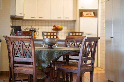 a kitchen with a table with wooden chairs and a kitchen at Bayview Studio in Kritharia