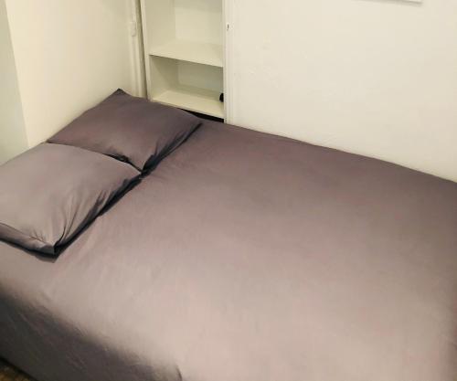 - un lit avec un oreiller gris dans l'établissement Room appart, à Narbonne