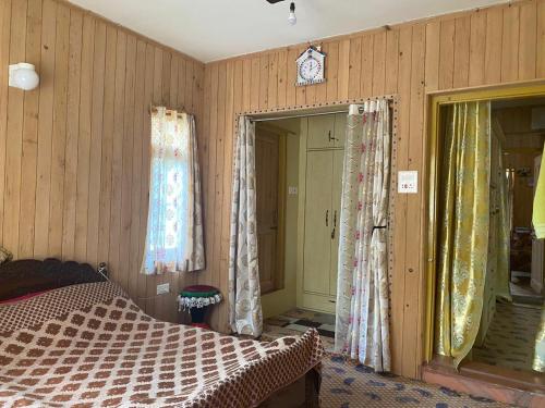 a bedroom with wooden walls and a bed and curtains at Himalayan Breeze Homestay in Srinagar