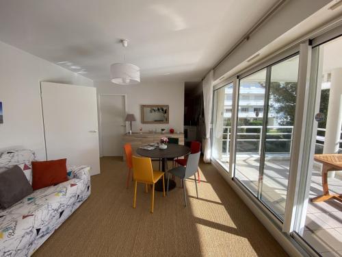 un salon avec une table, des chaises et un canapé dans l'établissement Appartement Moderne 6 Pers, Centre d'Arcachon, Parking Sécu, Ascenseur, Ménage Inclus - FR-1-474-97, à Arcachon