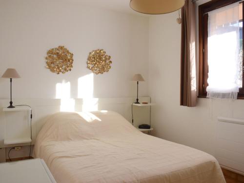 een witte slaapkamer met een bed en een raam bij Appartement Évian-les-Bains, 2 pièces, 4 personnes - FR-1-498-15 in Évian-les-Bains