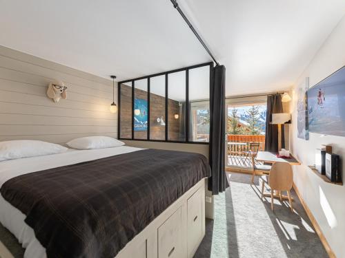 une chambre avec un grand lit et une grande fenêtre dans l'établissement Studio rénové, fonctionnel, proche pistes et remontées mécaniques, équipé pour 4 personnes, Méribel - FR-1-565-60, à Les Allues