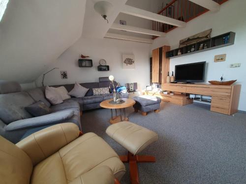a living room with a couch and a tv at Ferienwohnung Zweite Heimat 45248 in Ditzum
