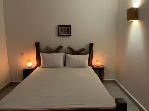 a bedroom with a large white bed with two lamps at Lala salama Kendwa villas in Kendwa
