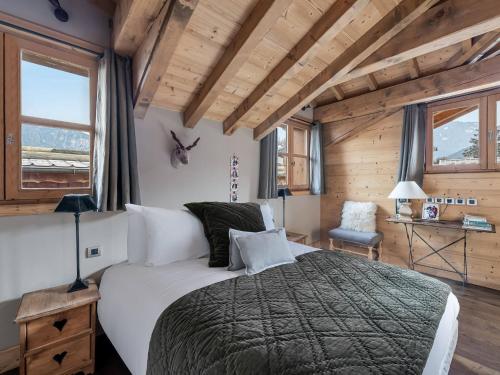 a bedroom with a large bed in a room with wooden ceilings at Chalet cosy au centre de Courchevel Le Praz avec sauna, terrasse et parking - FR-1-568-15 in Courchevel