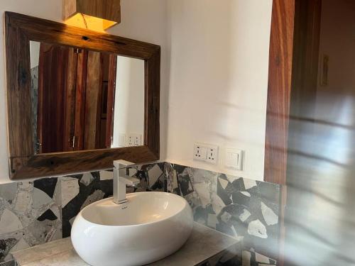 a bathroom with a white sink and a mirror at Lala salama Kendwa villas in Kendwa