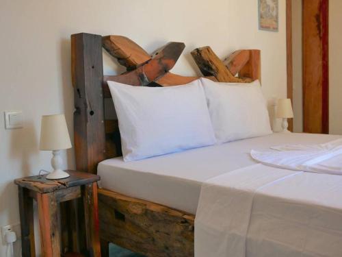a bedroom with a bed with a wooden headboard at Lala salama Kendwa villas in Kendwa
